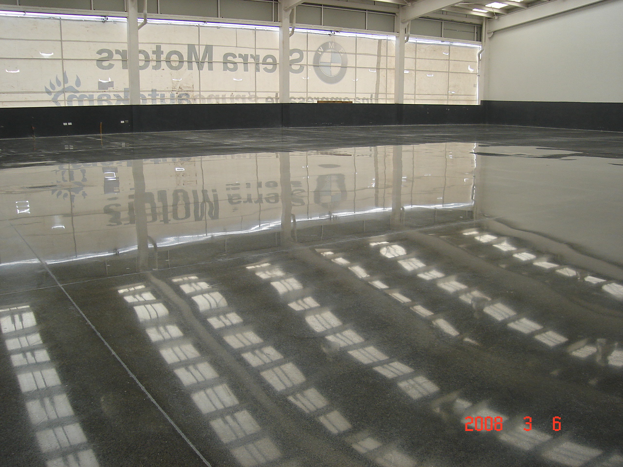 The shiny surface of a polished cement floor reflects the ceiling of a BMW facility in Monterrey, MX.